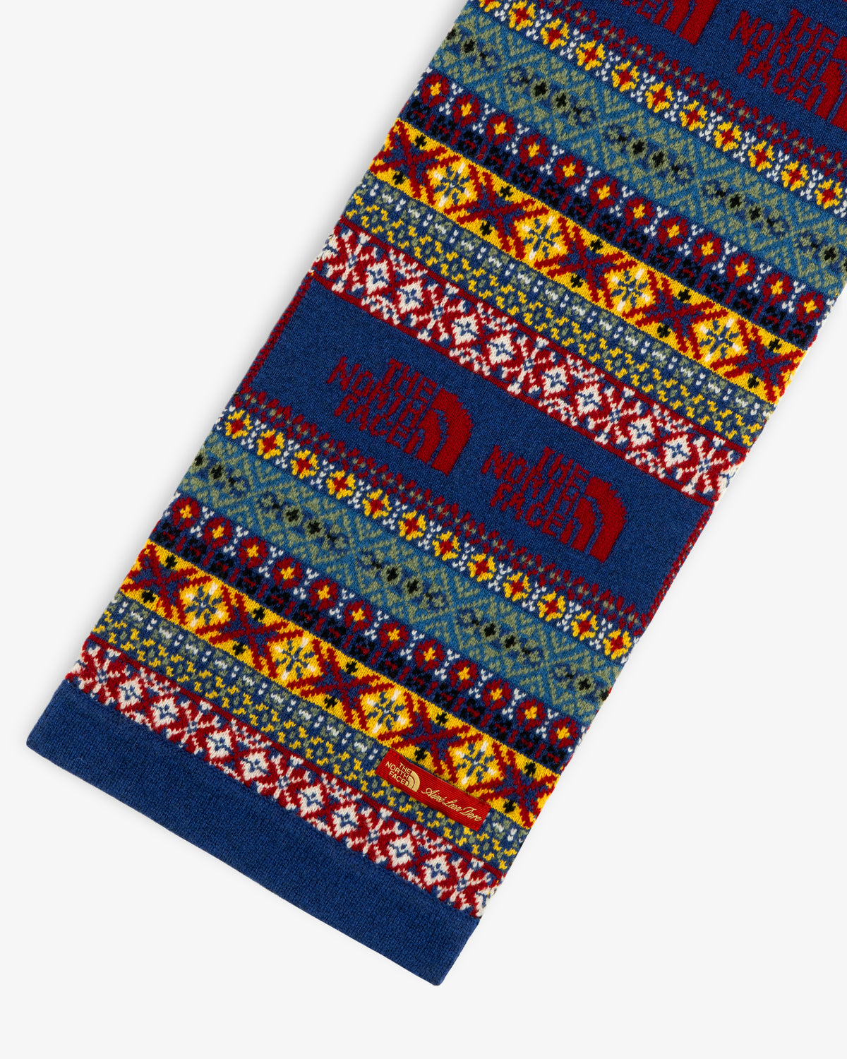 ALD / The North Face Fair Isle Scarf in blue, yellow, red & white with red logo, shown on white background.
