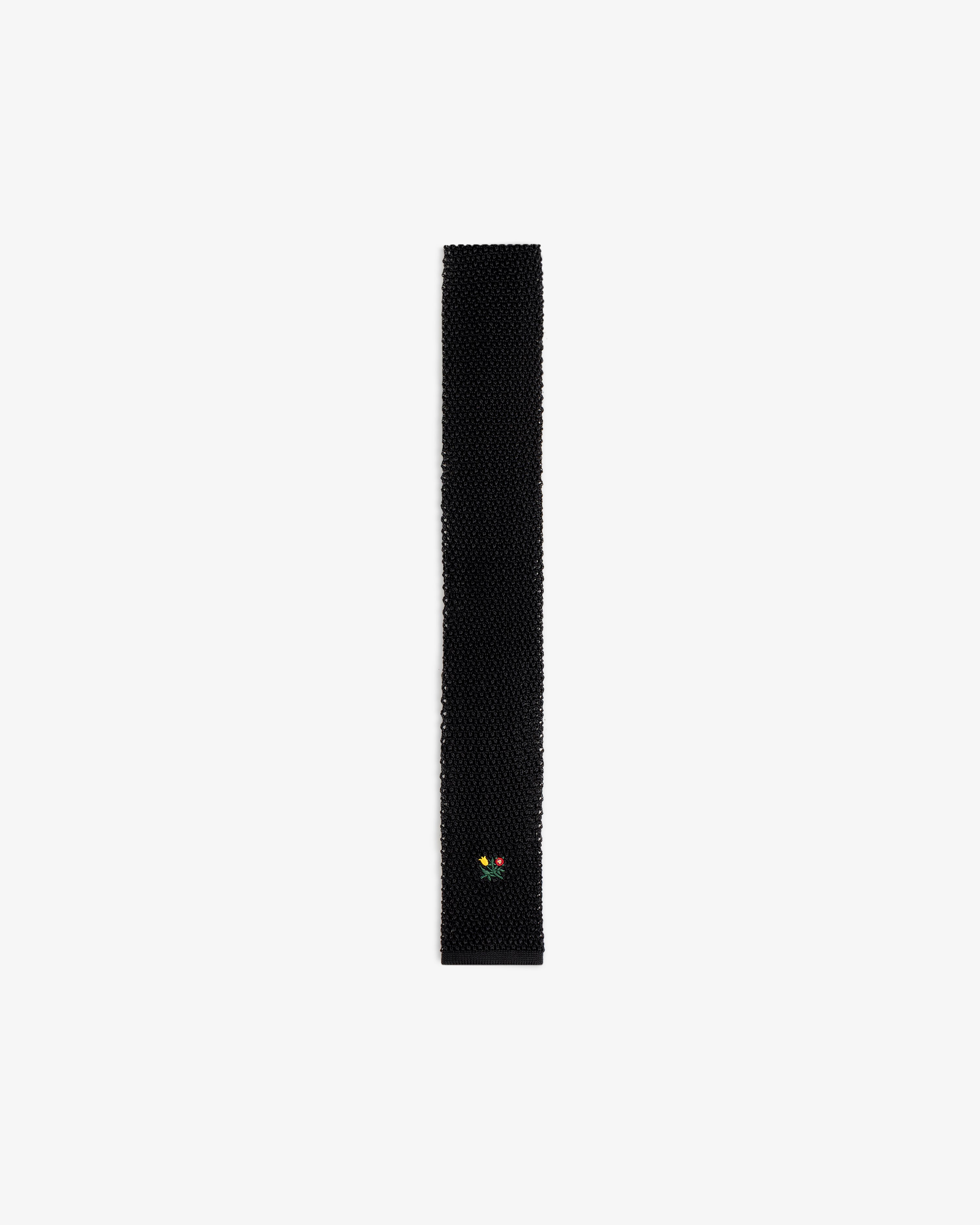 Crest Silk Knit Tie in black with small floral embroidery near the pointed tip.