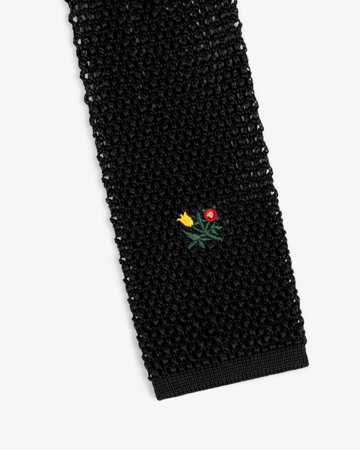 Crest Silk Knit Tie in black with a small embroidered floral motif.