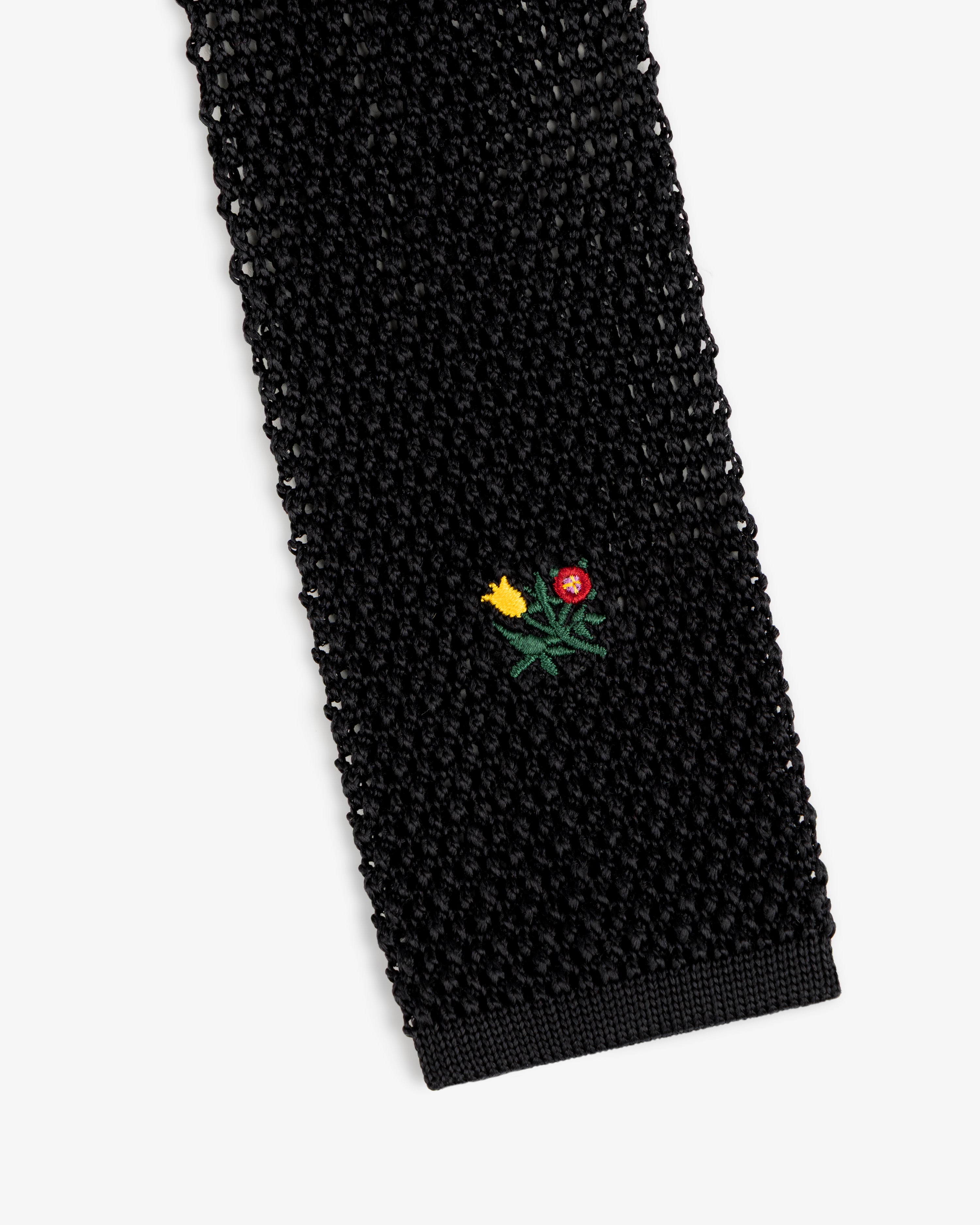 Crest Silk Knit Tie in black with a small embroidered floral motif.