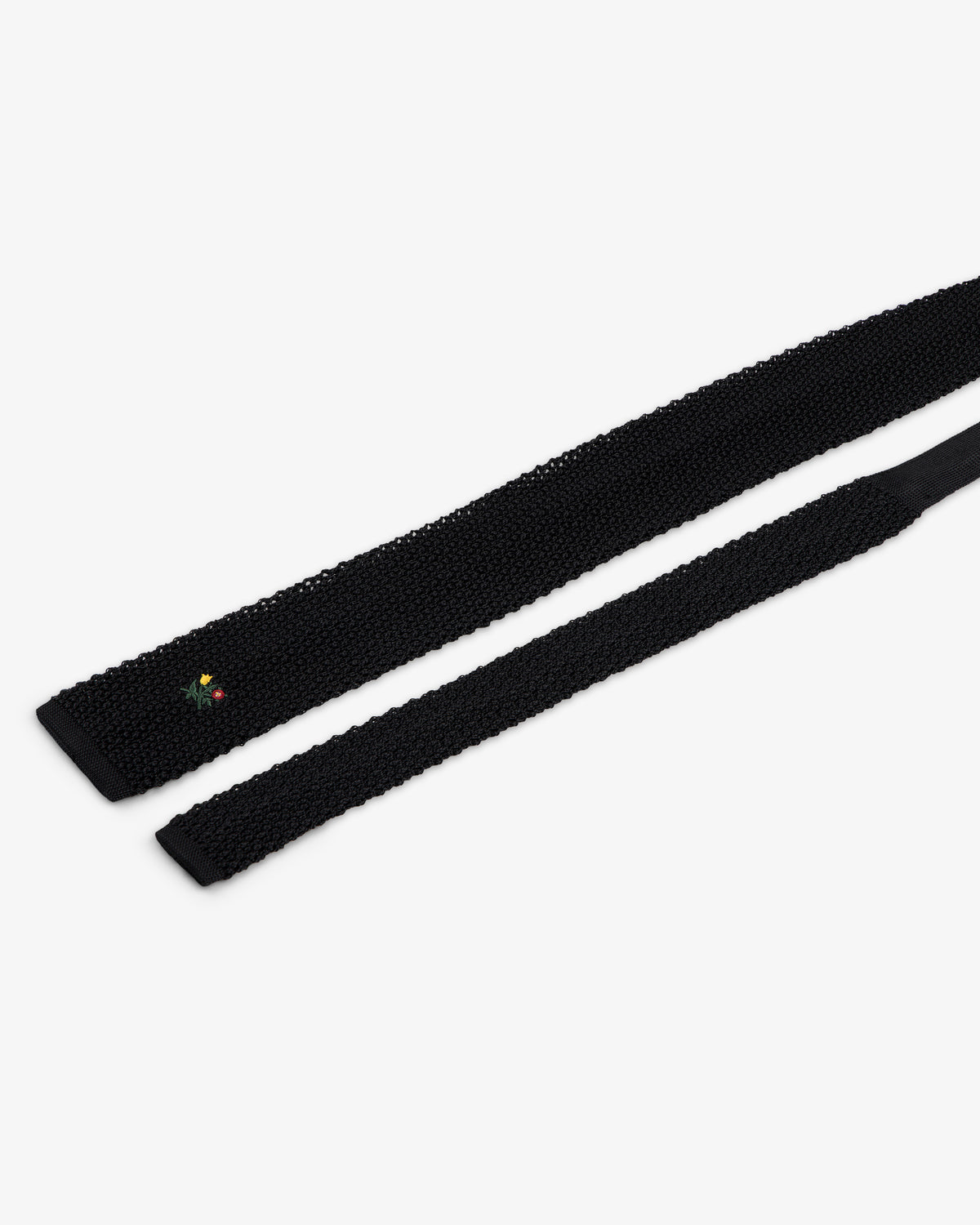 Crest Silk Knit Tie in black, featuring small floral embroidery near the tip.