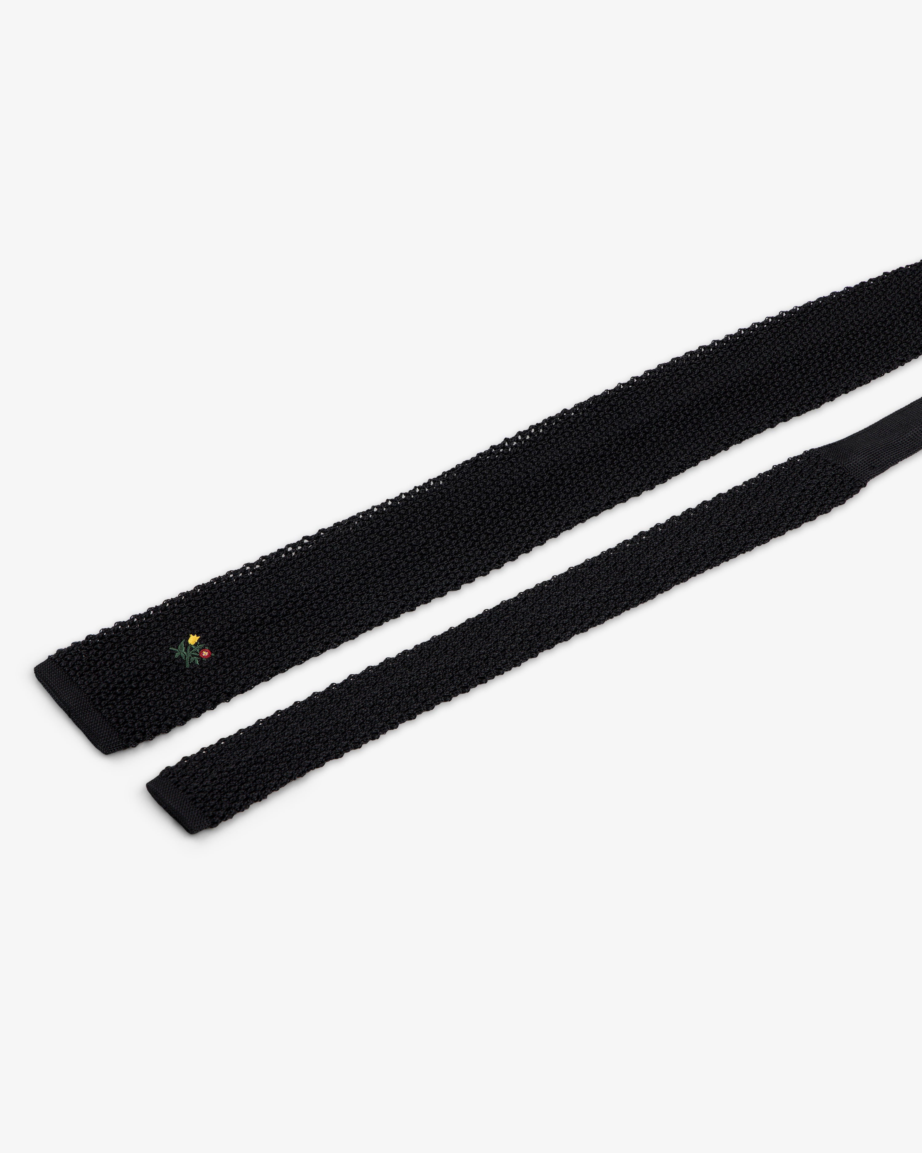 Crest Silk Knit Tie in black, featuring small floral embroidery near the tip.