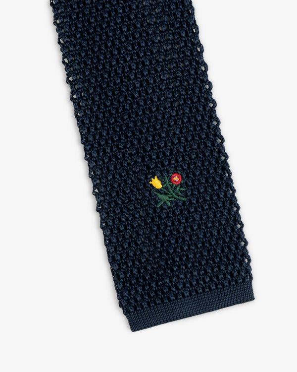 Crest Silk Knit Tie in dark navy with a small embroidered floral motif.