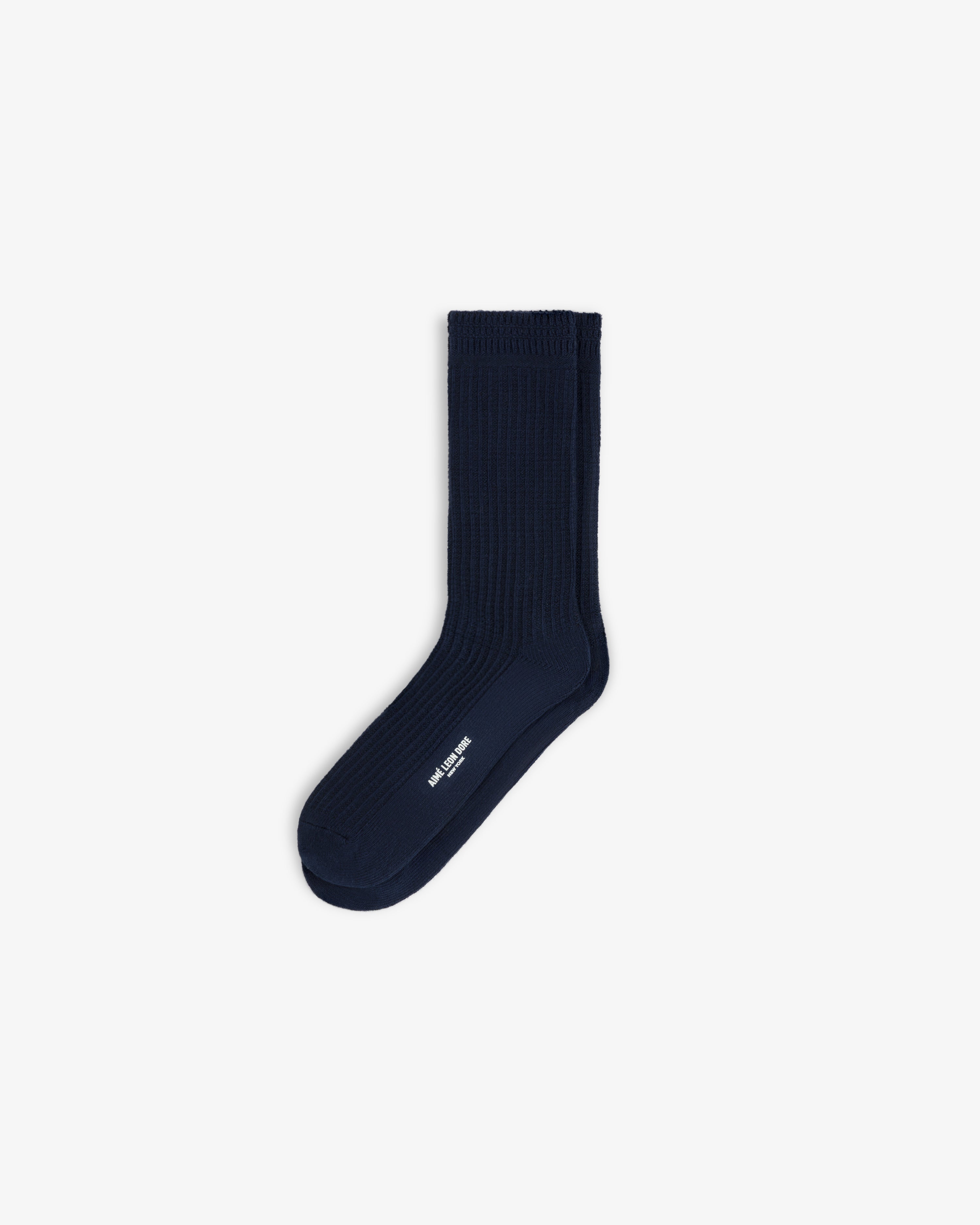 A navy blue ribbed Cotton Waffle Sock with white logo text on the side.