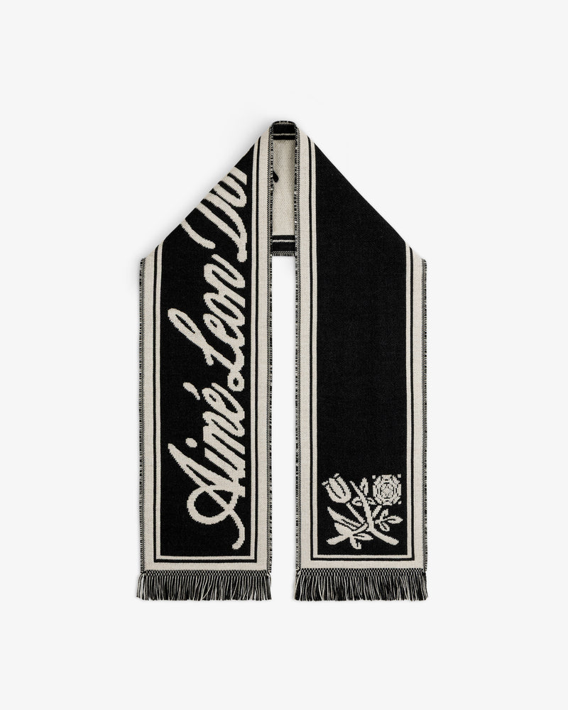 Wool Script Scarf in black and off-white with a script logo on one end, a floral graphic on the other, and fringe trim.
