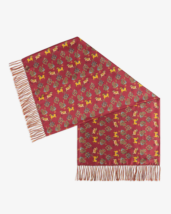 Archival Print Silk Fringe Scarf in red silk with a repeating pattern of yellow animals and teal birds, with fringed ends.