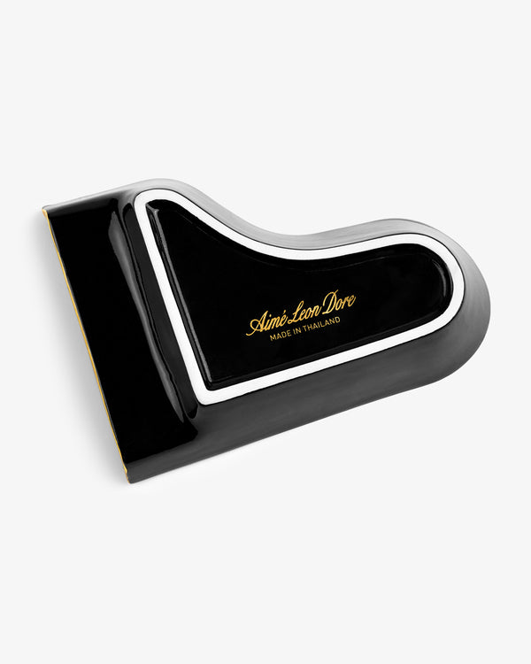 Piano Ashtray in black and white, shaped like a grand piano lid with gold “Aimé Leon Dore Made in Thailand” text.