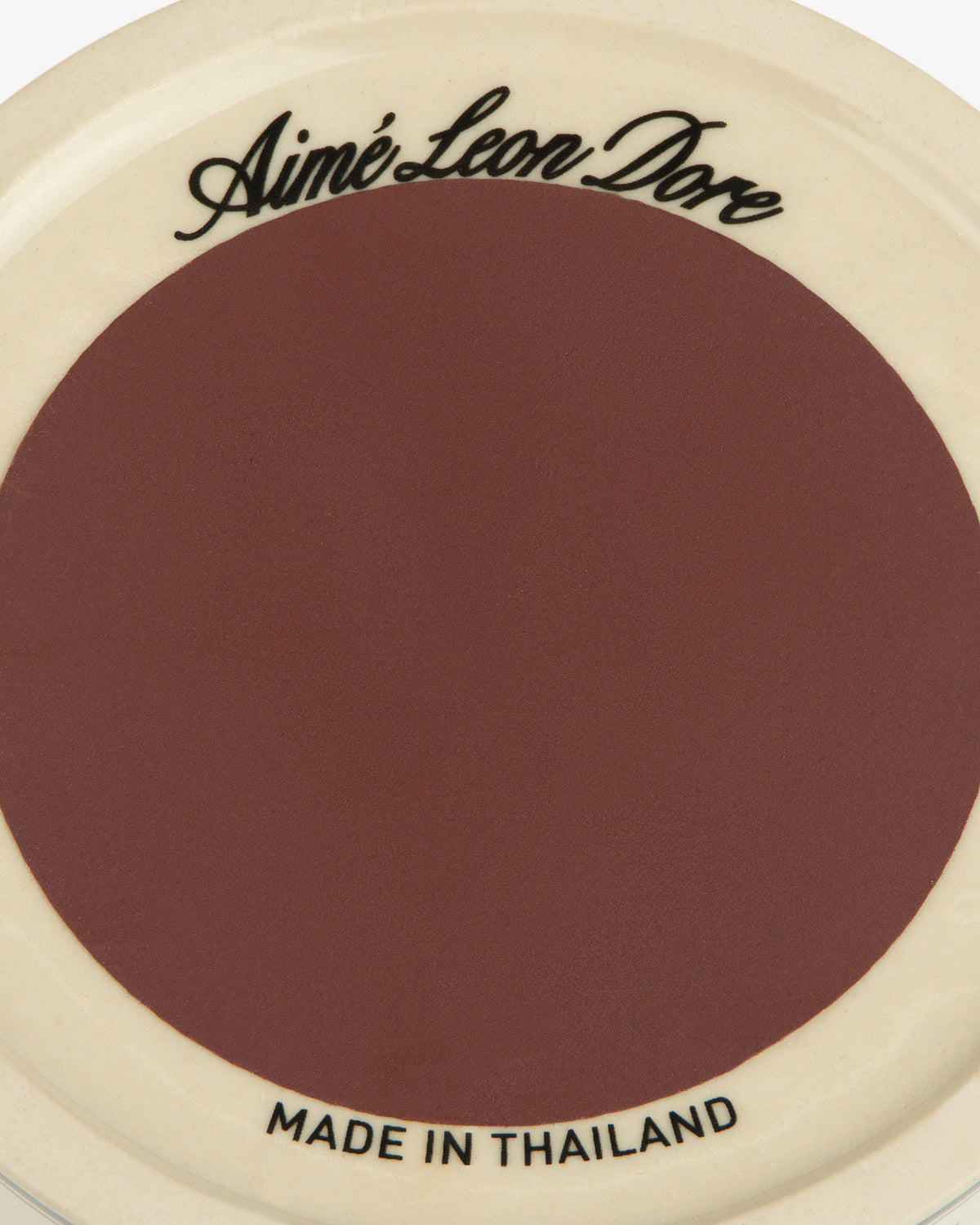 Porcelain Match Striker: maroon center, cream rim, Aimé Leon Dore on top, MADE IN THAILAND on bottom.