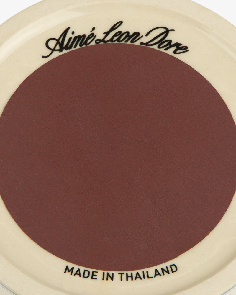 Porcelain Match Striker: maroon center, cream rim, Aimé Leon Dore on top, MADE IN THAILAND on bottom.