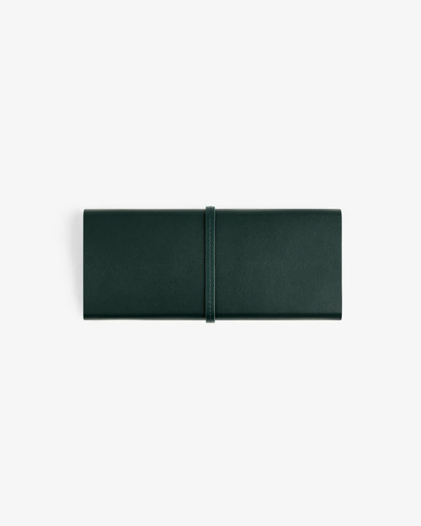 A closed Brass Measurement Kit with a wrap-around strap in dark green leather, on a white background.