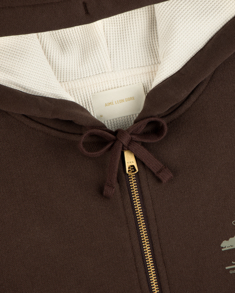 Close-up of the Unisphere Waffle Lined Full-Zip Hoodie with a gold zipper, cream lining, and neck bow.