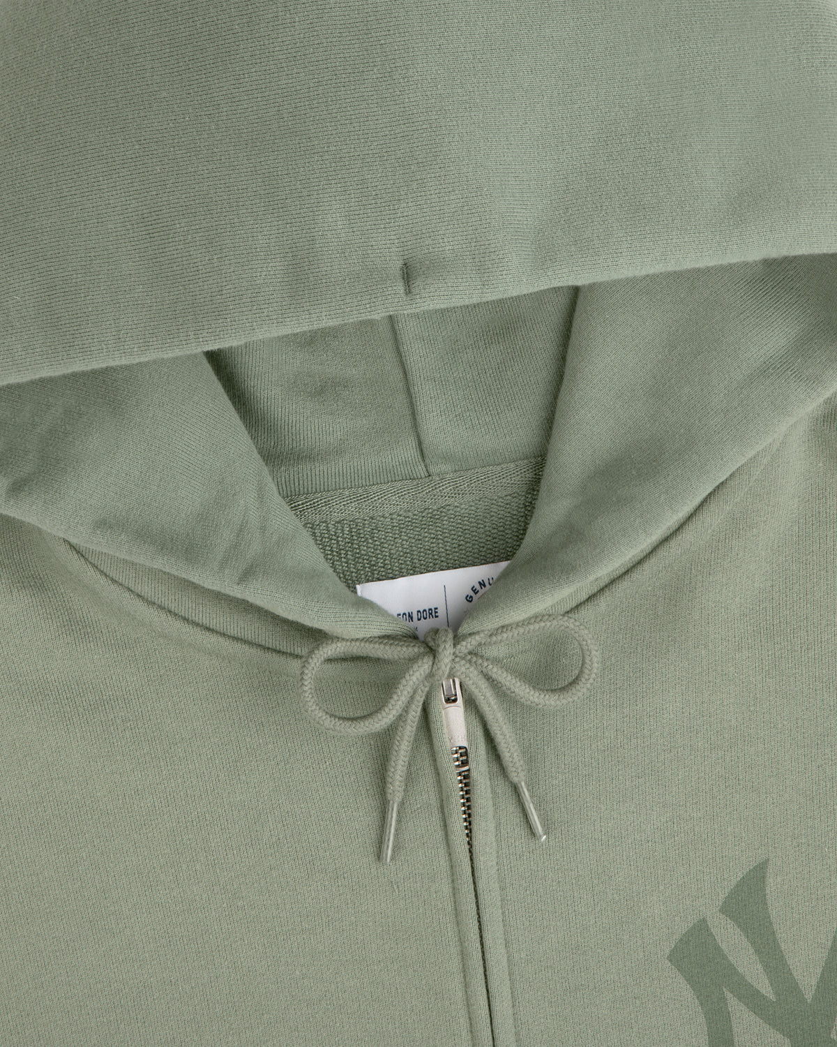 Yankees Washed Full-Zip Hoodie in sage green, hood up, zipper and drawstring bow visible, tag peeking inside.