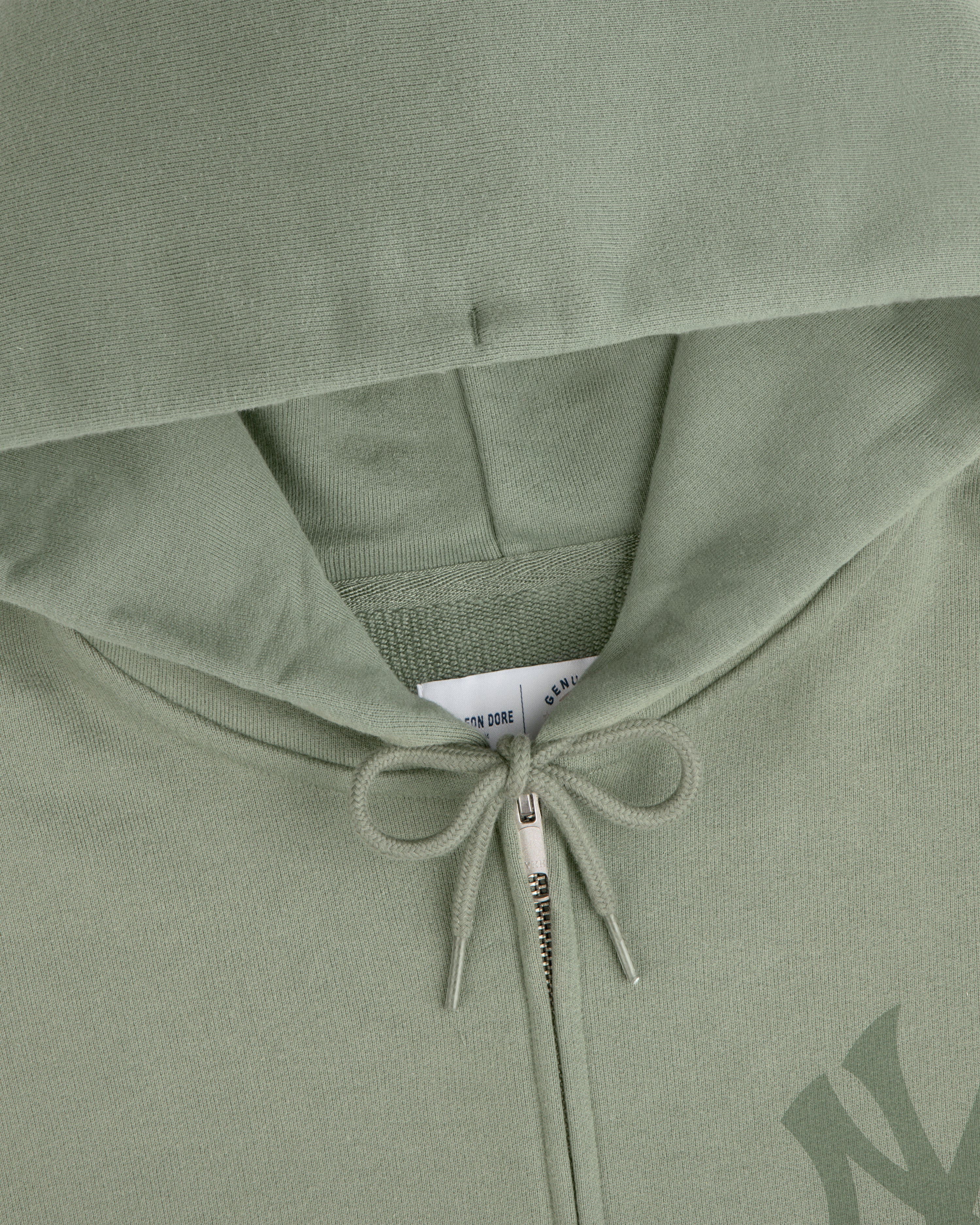 Yankees Washed Full-Zip Hoodie in sage green, hood up, zipper and drawstring bow visible, tag peeking inside.