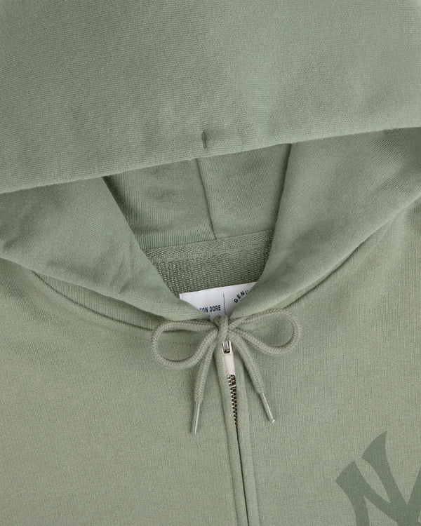 Yankees Washed Full-Zip Hoodie in sage green, hood up, zipper and drawstring bow visible, tag peeking inside.