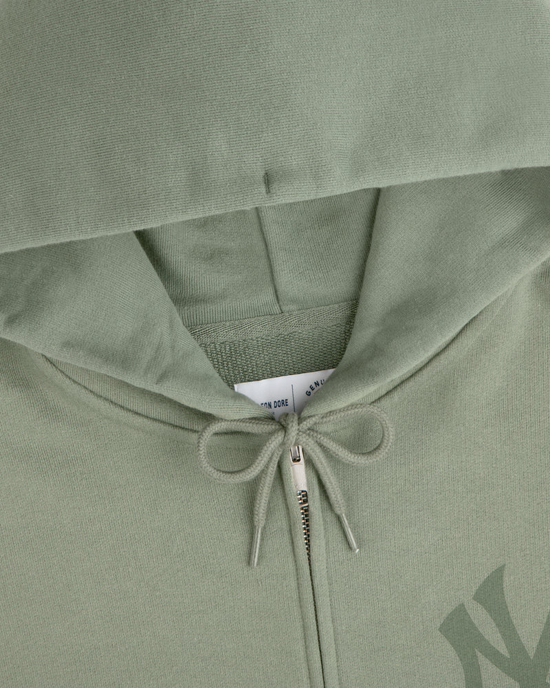 Yankees Washed Full-Zip Hoodie in sage green, hood up, zipper and drawstring bow visible, tag peeking inside.
