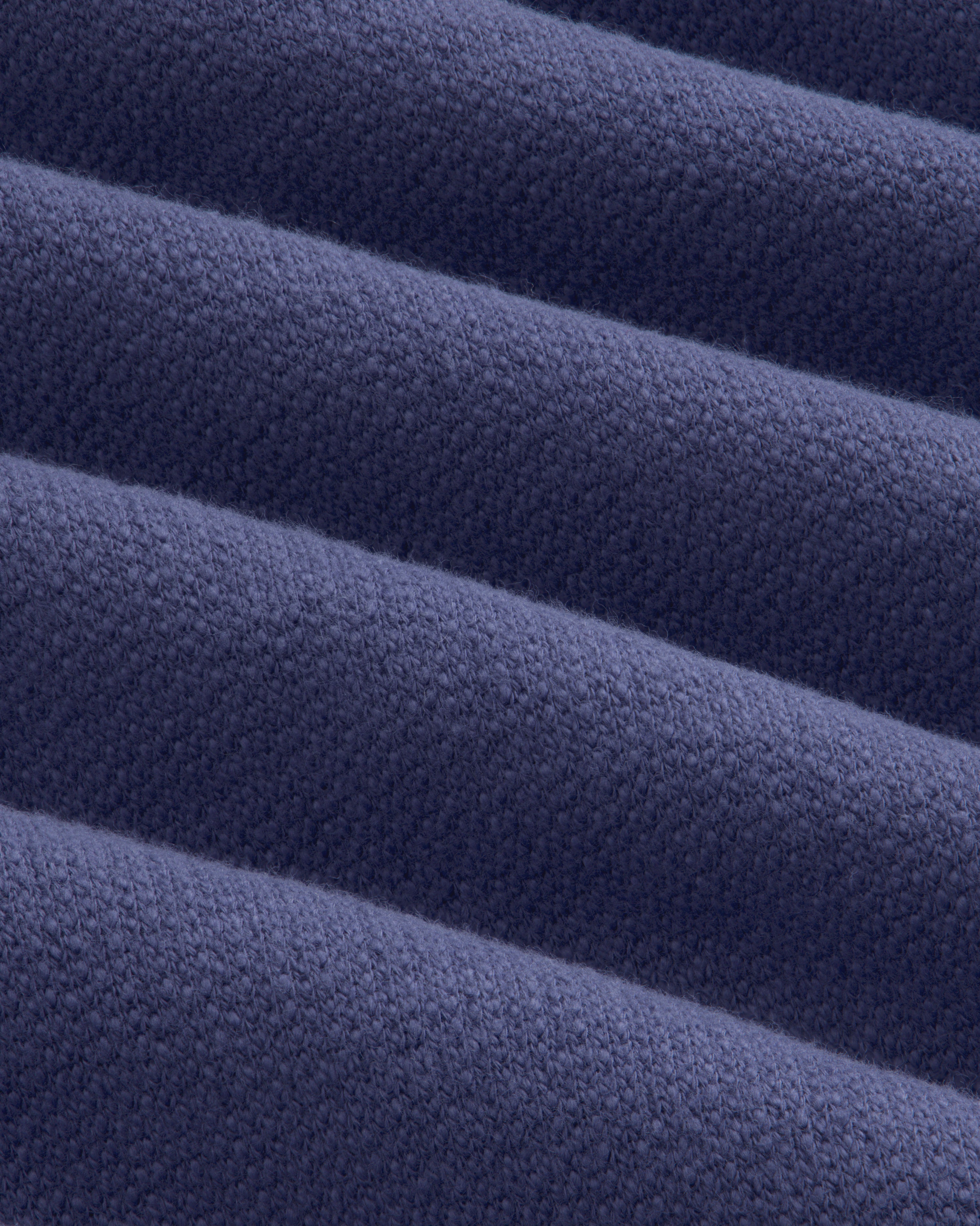 Close-up of Stone Washed Marina Sweatpants: folded dark blue fabric with textured weave and soft, raised ridges.