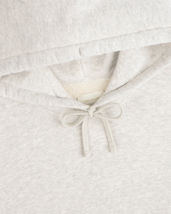 Close-up of the Stone Washed Marina Hoodie in light gray with tied drawstring and a clothing label inside the hood.