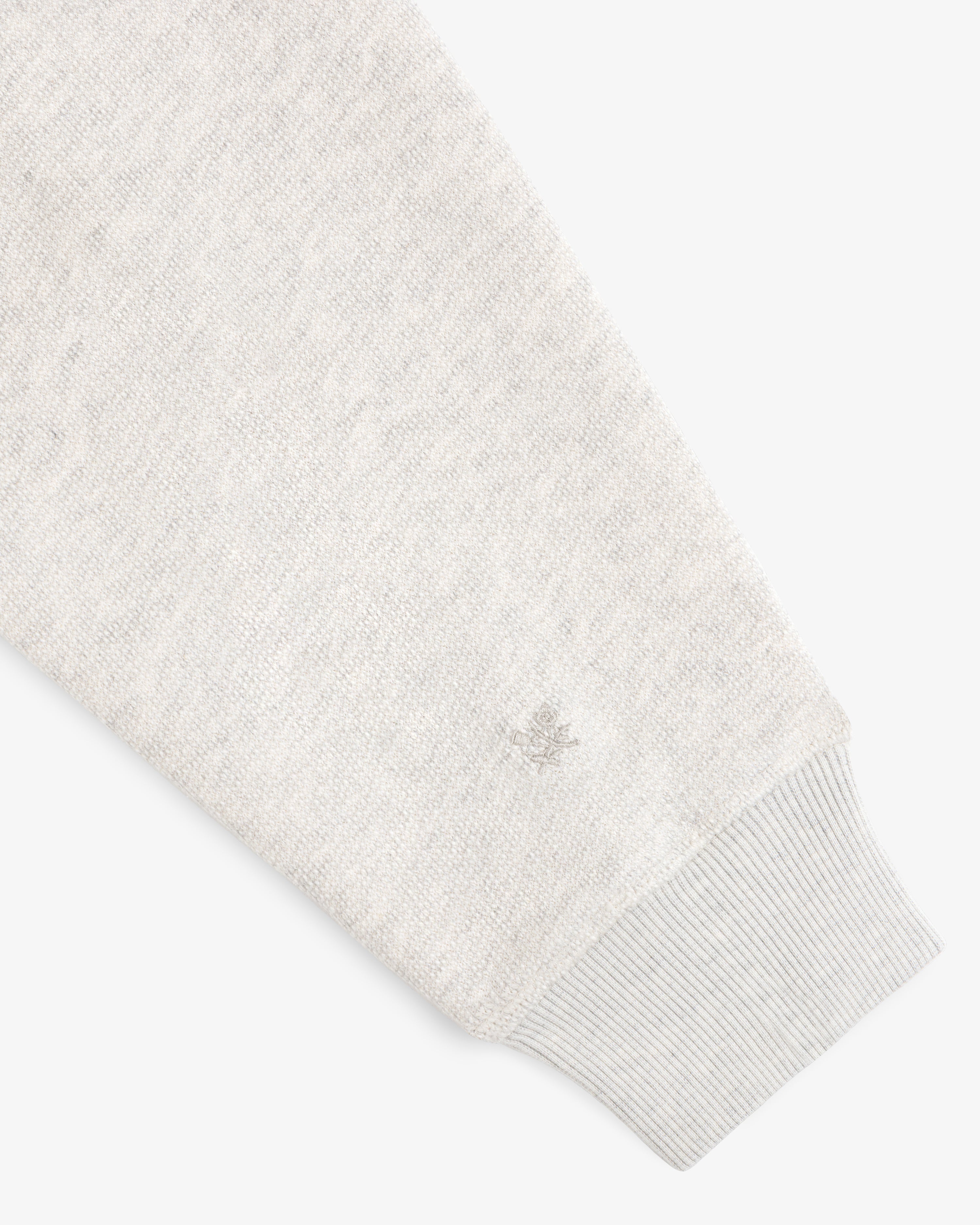 Stone Washed Marina Hoodie in light gray knit, long sleeves, ribbed cuffs, and small wrist logo embroidery.