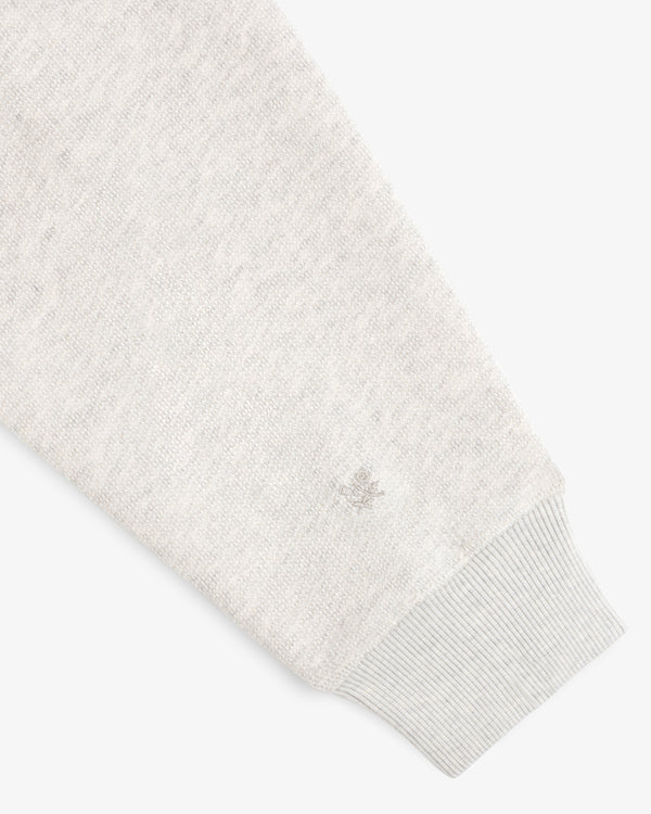 Stone Washed Marina Hoodie in light gray knit, long sleeves, ribbed cuffs, and small wrist logo embroidery.