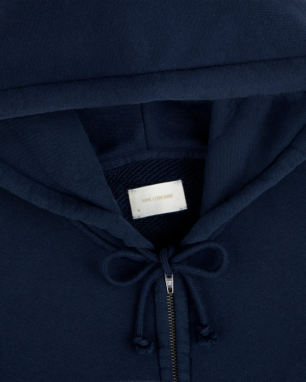Close-up of a navy blue Script Full Zip Hoodie featuring a branded neck label.