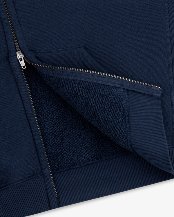 Close-up of a navy blue Script Full Zip Hoodie, highlighting the metal zipper and textured fleece interior.