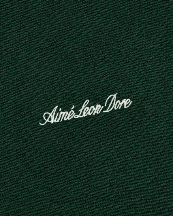 Script Full Zip Hoodie in dark green fabric featuring white cursive Aimé Leon Dore embroidery.