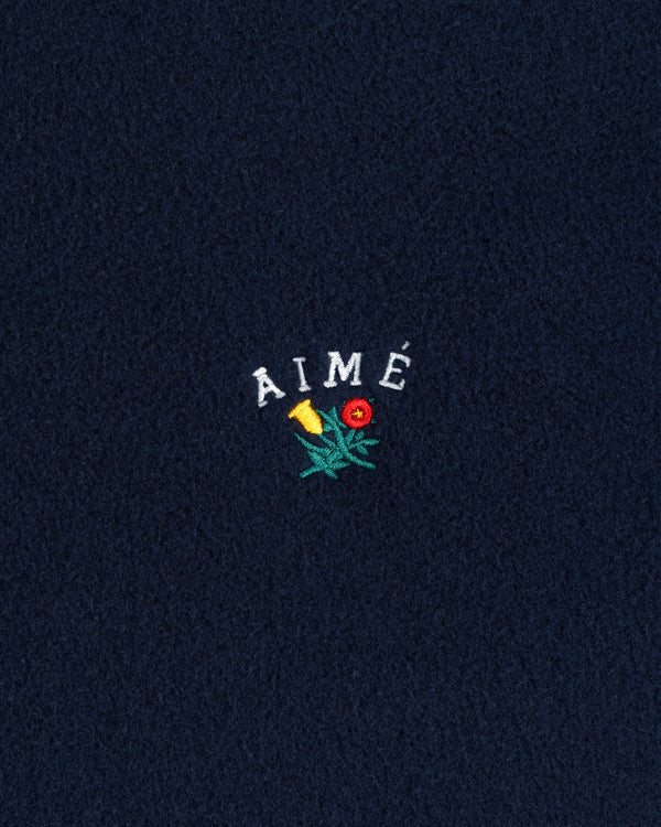 Navy Crest Fleece Full-Zip Hoodie with AIMÉ text and a small embroidered yellow-red flower with green leaves.