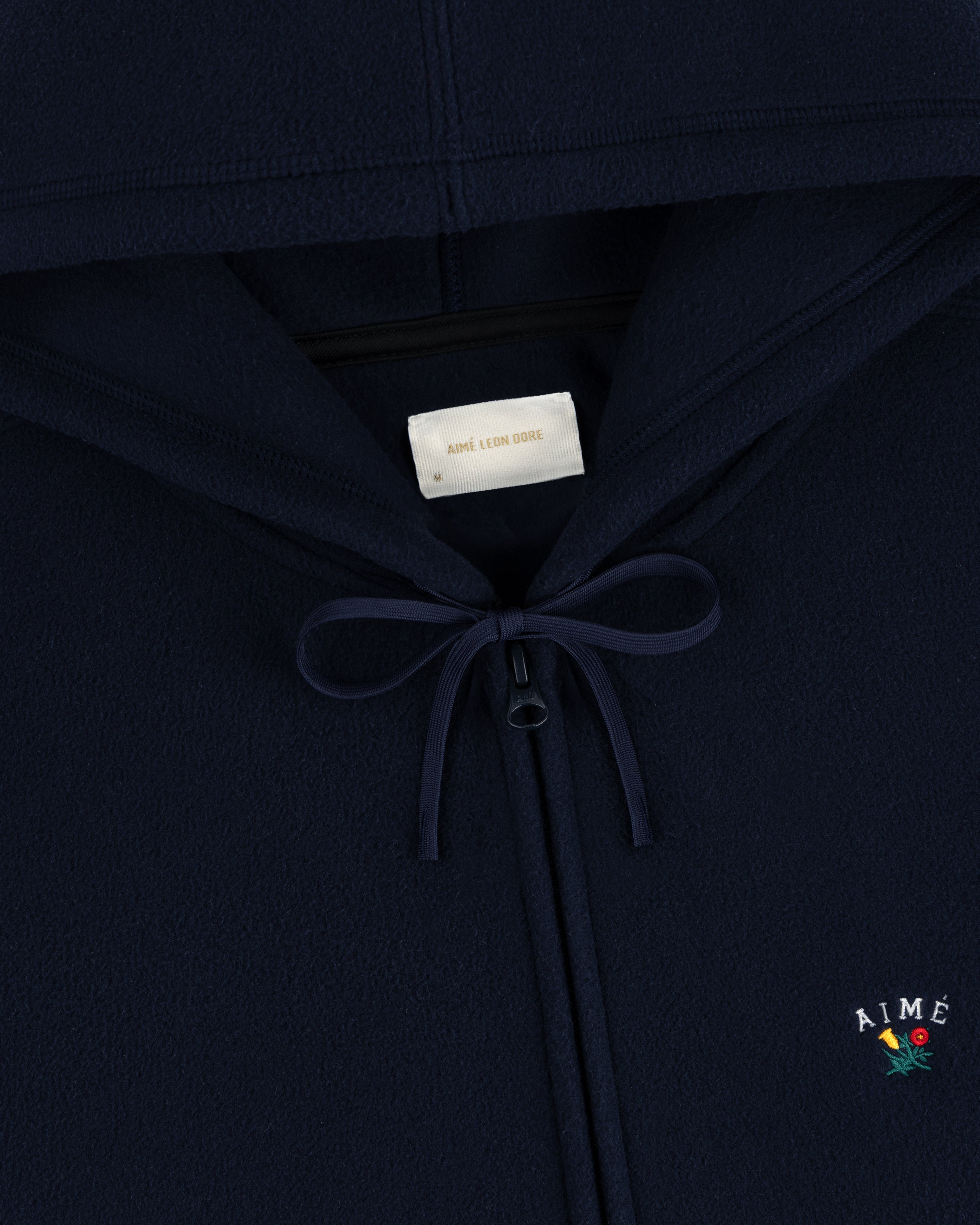 Navy Crest Fleece Full-Zip Hoodie with bow neckline, inner label, and Aimé Leon Dore logo with small flower embroidery.