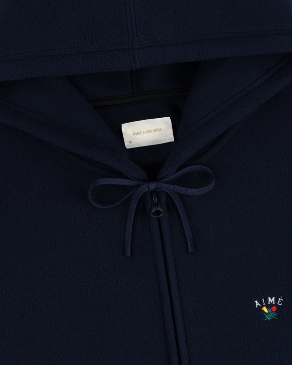 Navy Crest Fleece Full-Zip Hoodie with bow neckline, inner label, and Aimé Leon Dore logo with small flower embroidery.