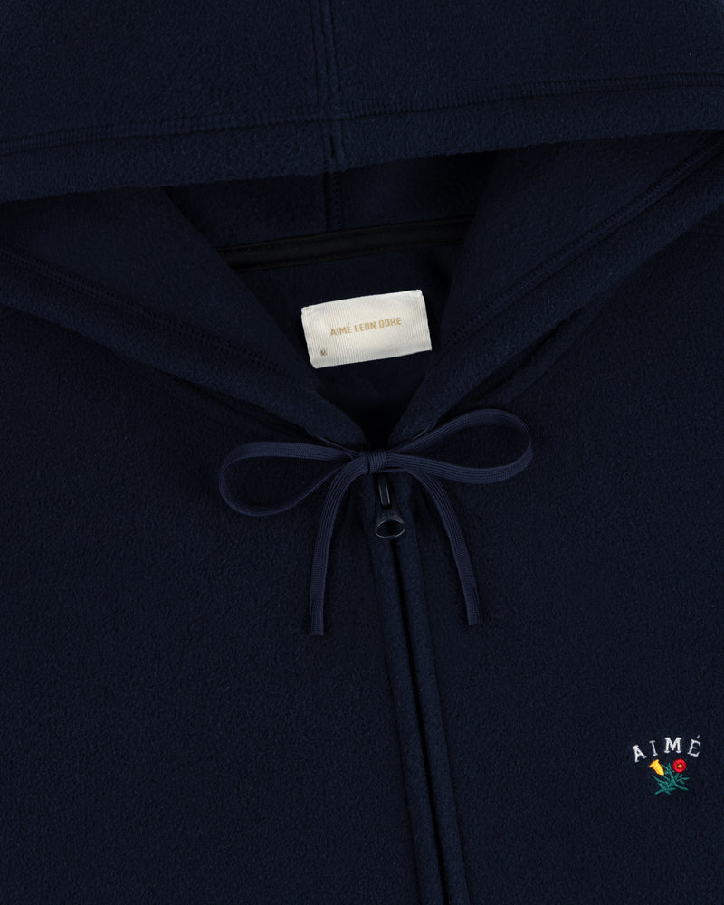 Navy Crest Fleece Full-Zip Hoodie with bow neckline, inner label, and Aimé Leon Dore logo with small flower embroidery.