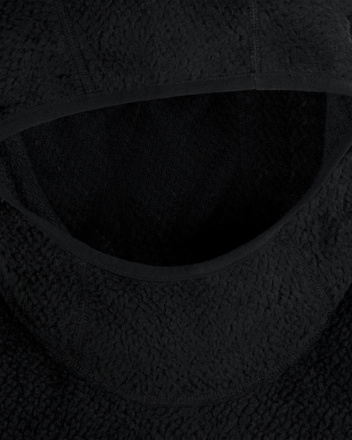 Close-up of a black textured Fleece Performance Hoodie hood with smooth fabric trim.