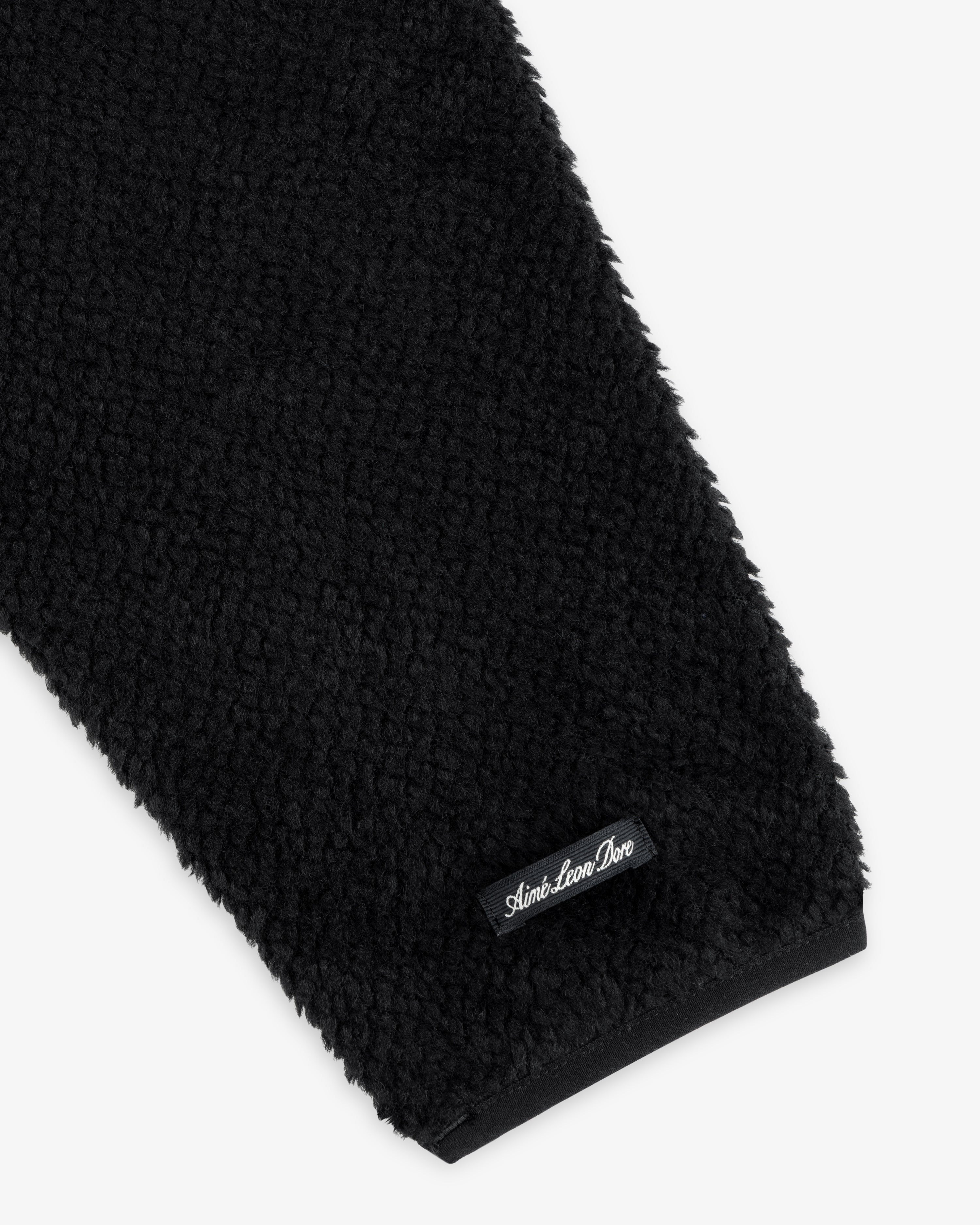 Black fleece sleeve of a Fleece Performance Hoodie with a small black brand label at the cuff.