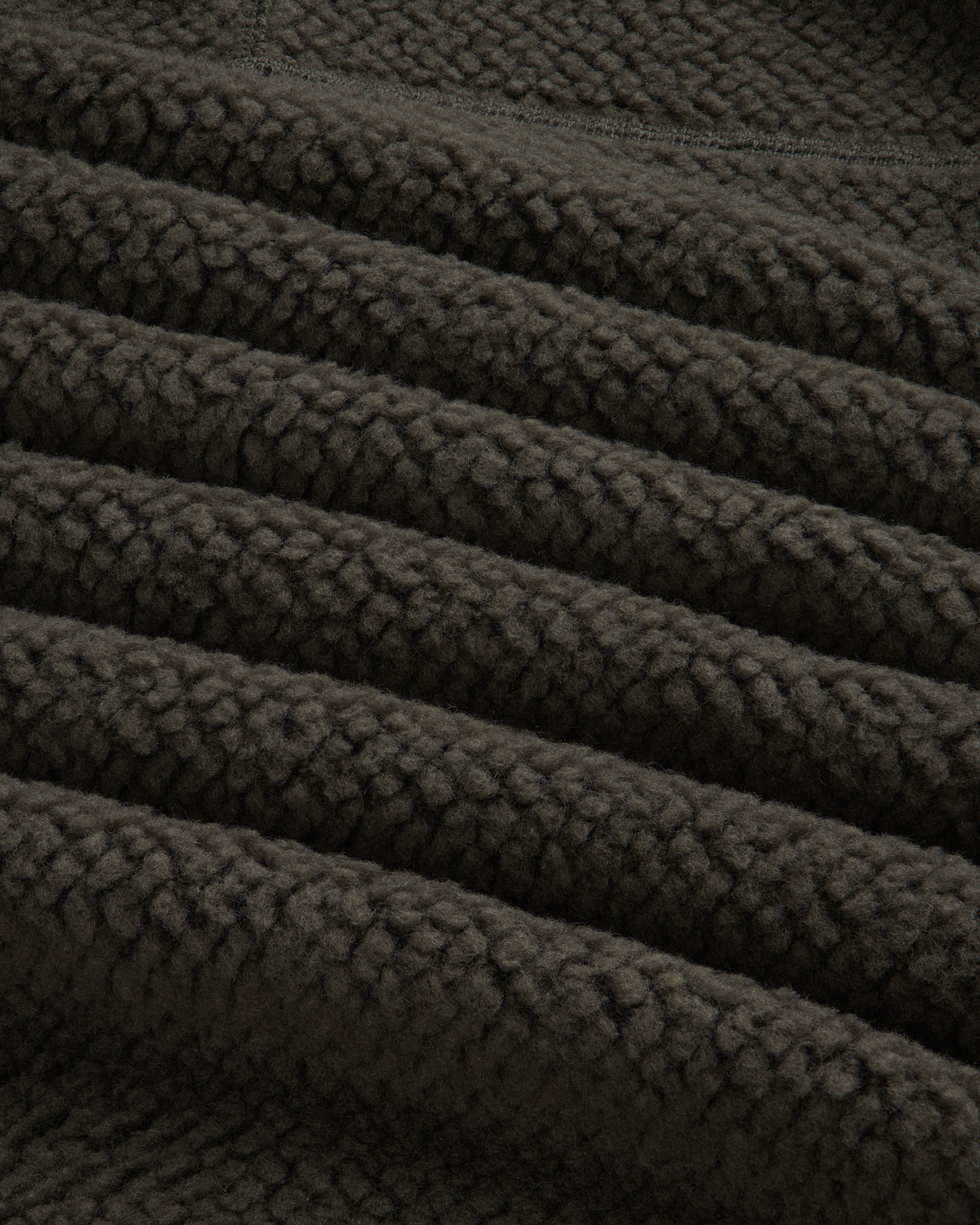 Close-up of the textured dark olive green fabric of a Fleece Performance Hoodie.