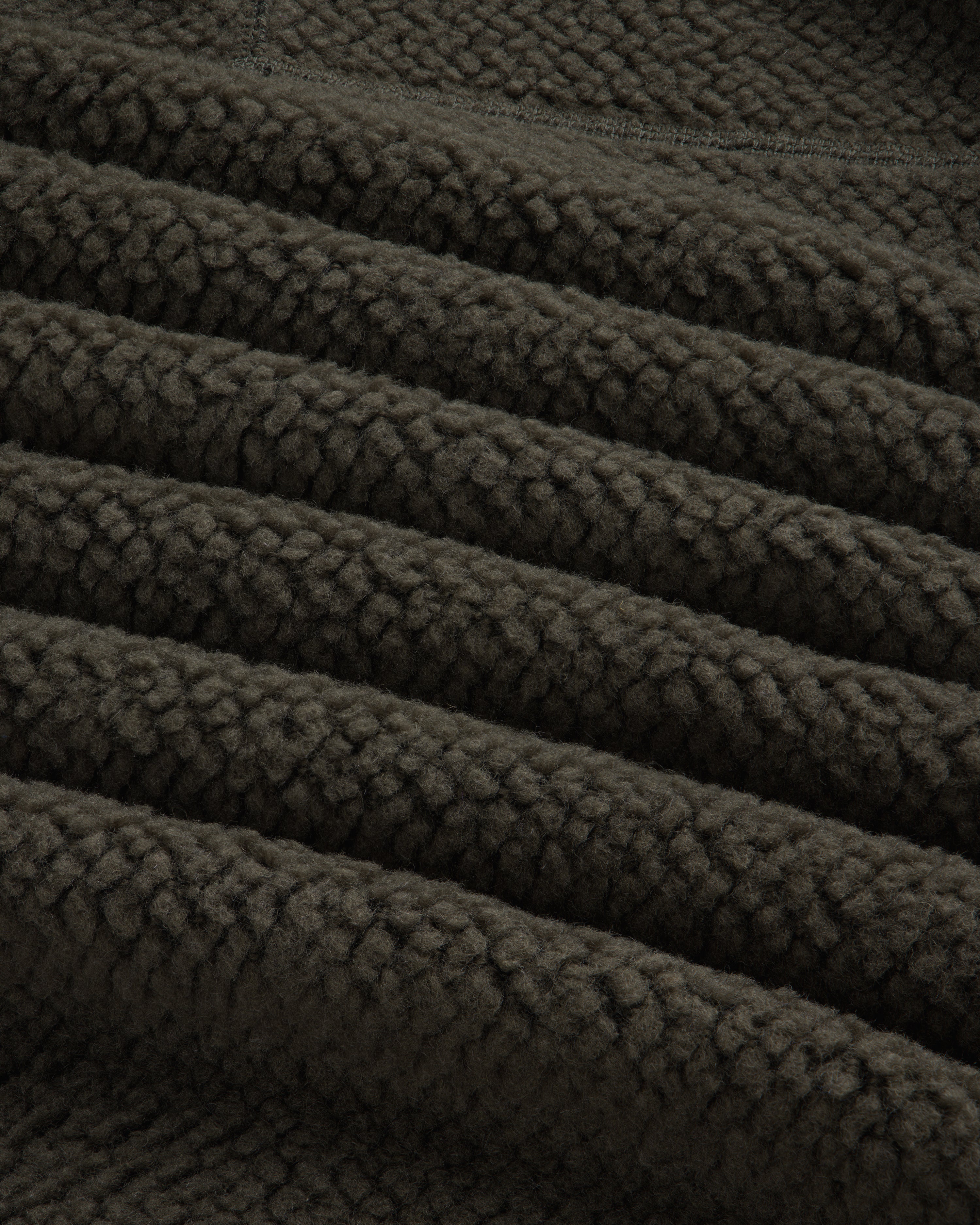 Close-up of the textured dark olive green fabric of a Fleece Performance Hoodie.
