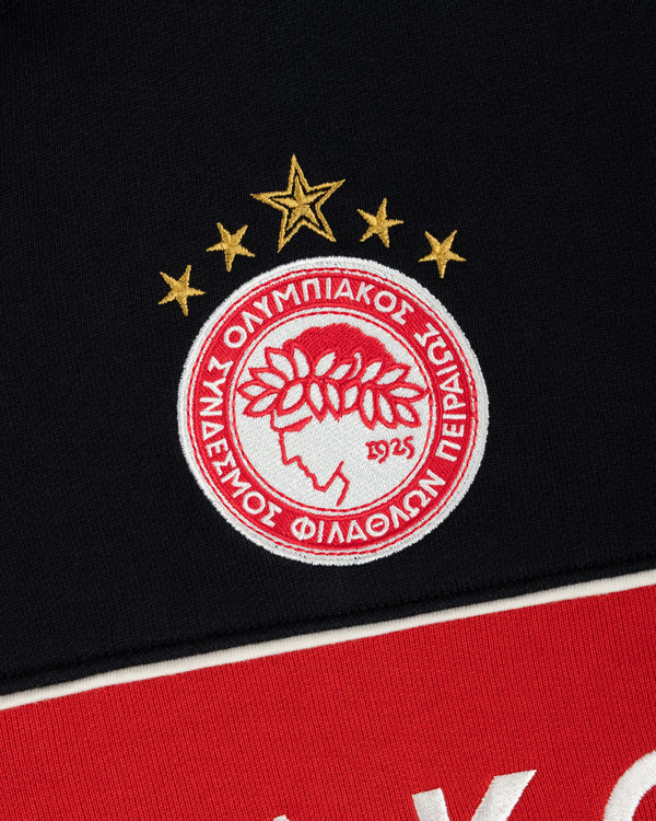 Embroidered Olympiacos F.C. crest patch on a black and red ALD / Olympiacos F.C. Full Zip Hoodie.