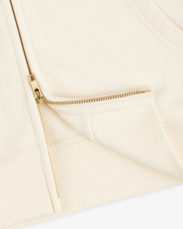 Close-up of a cream-colored ALD / Olympiacos F.C. Full Zip Hoodie with a gold-toned metal zipper.