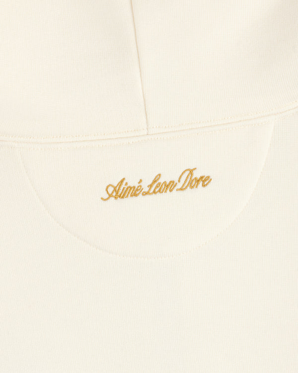 Cream-colored ALD / Olympiacos F.C. Full Zip Hoodie with gold embroidered script text on the upper back.