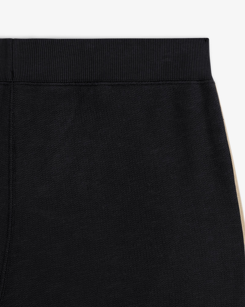 Close-up of Saint George Track Pant—black with a ribbed waistband and beige side stripe.