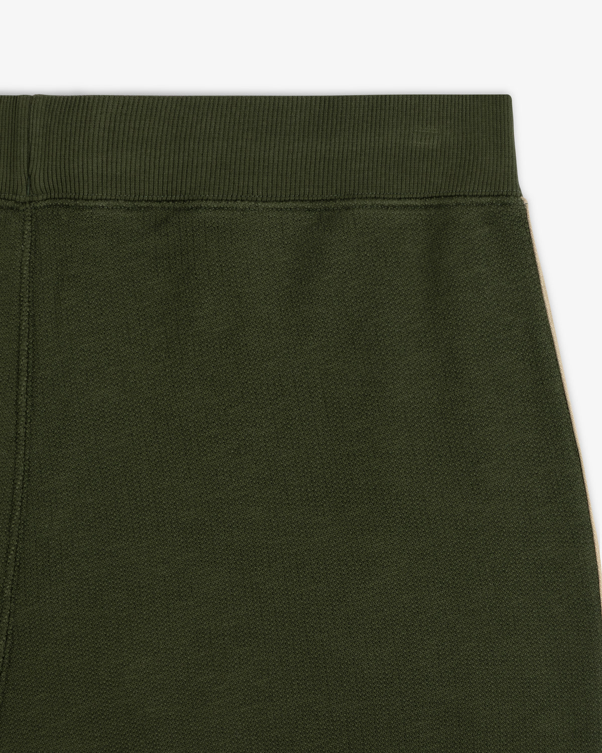 Close-up of the upper part of Saint George Track Pant in dark green with an elastic waistband.