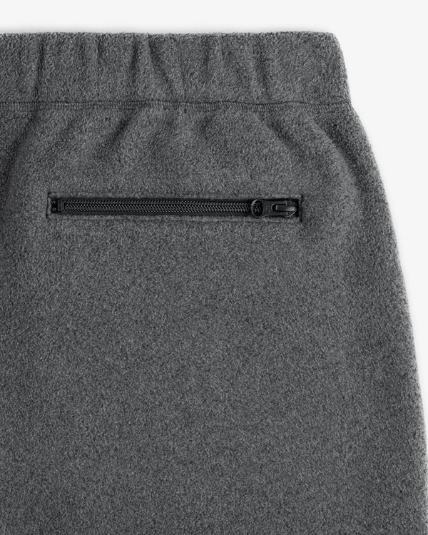 Close-up of Crest Fleece Sweatpant in gray with an elastic waistband and black zippered side pocket.