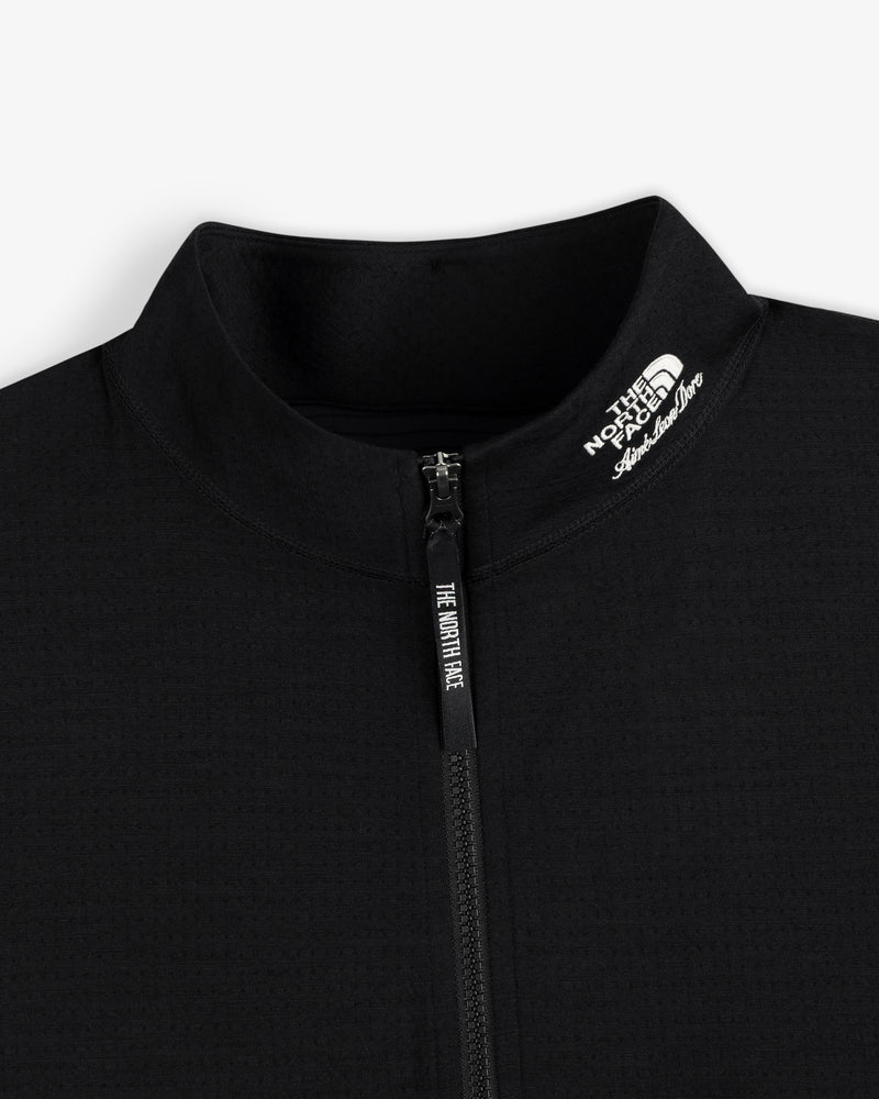 Close-up of a black ALD/The North Face DOTKNIT™ Wool Quarter Zip, logo on collar, on a white background.