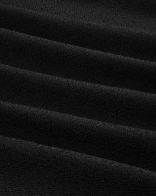 Close-up of ALD / The North Face DOTKNIT™ Wool Quarter Zip in black, showing diagonal textured folds and shadows.