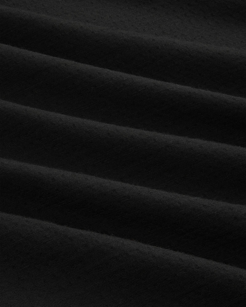 Close-up of ALD / The North Face DOTKNIT™ Wool Quarter Zip in black, showing diagonal textured folds and shadows.