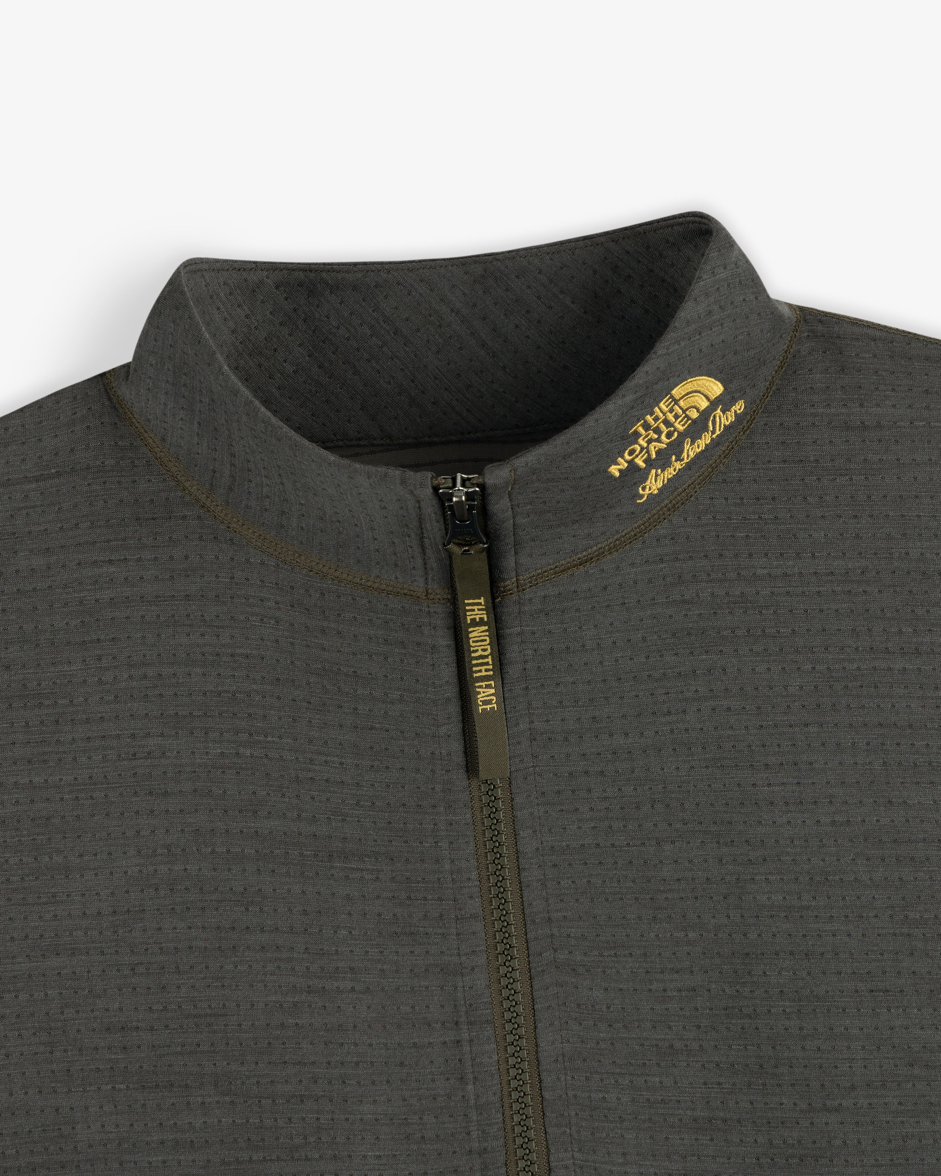 Close-up of the ALD / The North Face DOTKNIT™ Wool Quarter Zip in dark gray, logos by the collar visible.