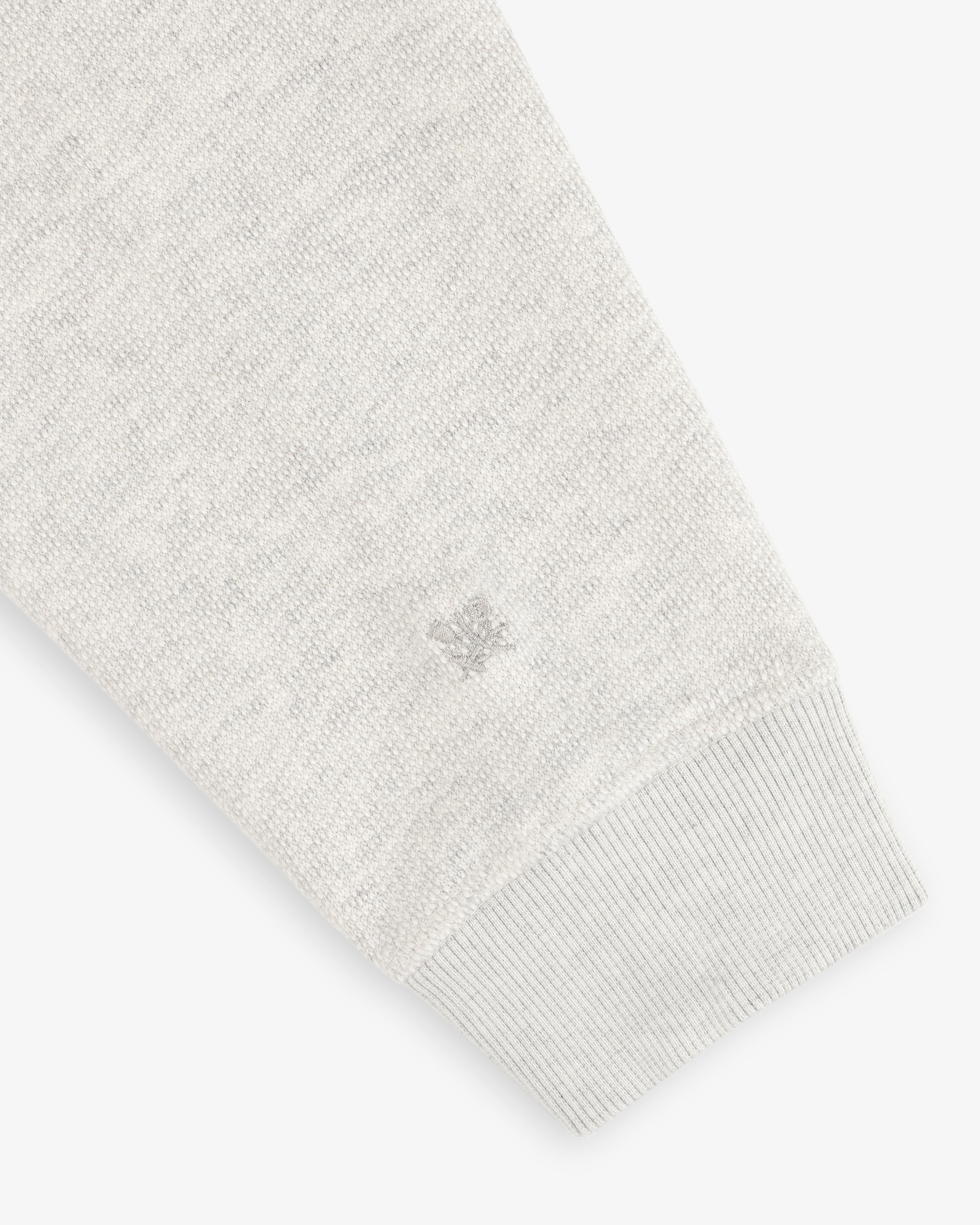 Stone Washed Marina Crewneck sleeve with ribbed cuff, textured fabric, and small logo embroidery near the wrist.
