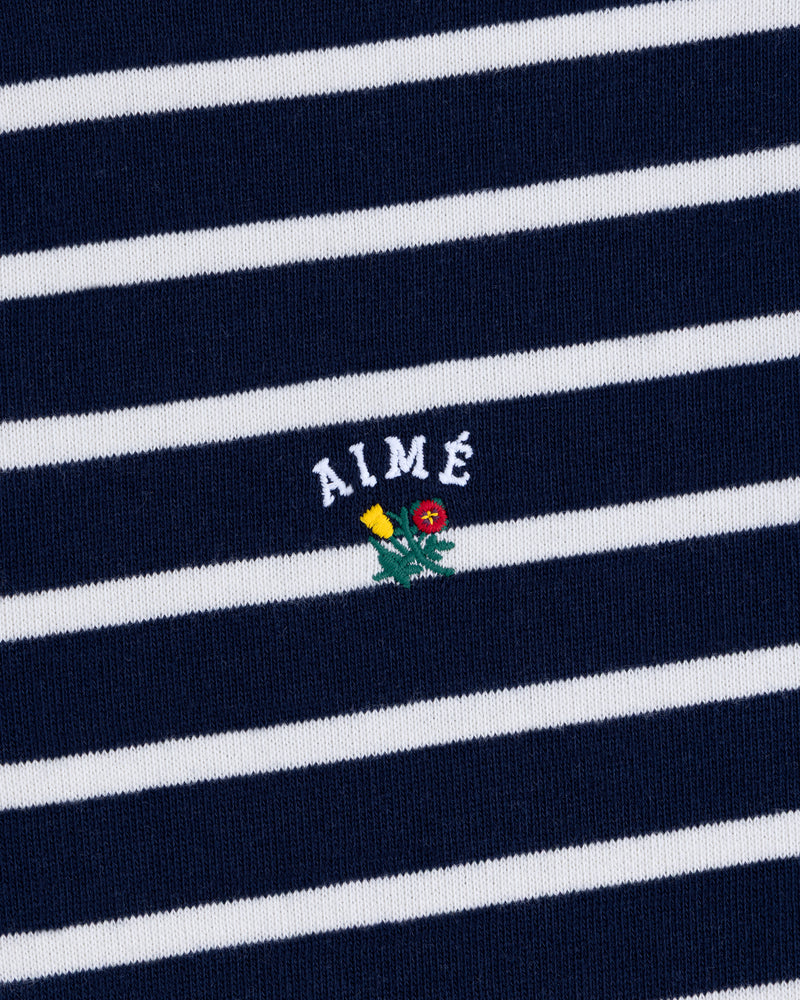 Striped Crest Quarter Zip in navy and white with AIMÉ text and a small embroidered yellow and red flower beneath.