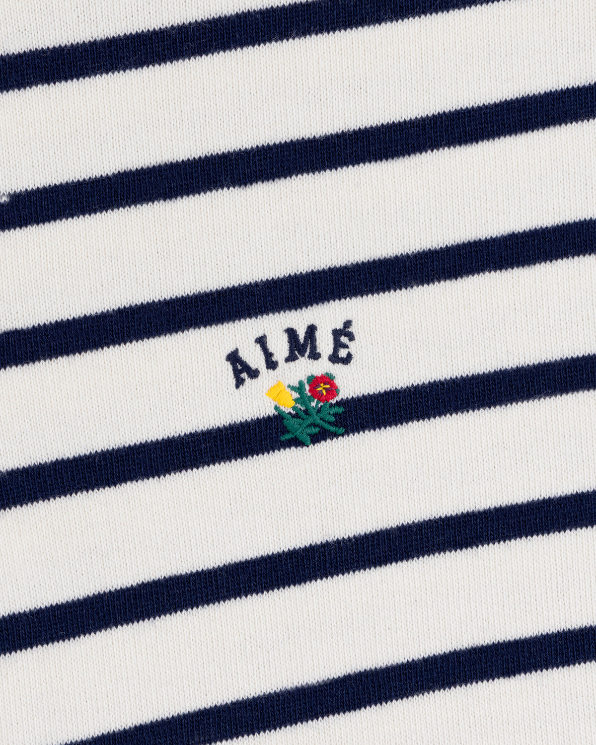 Striped Crest Quarter Zip: White with navy stripes, AIMÉ text, and small yellow/red embroidered flowers below.