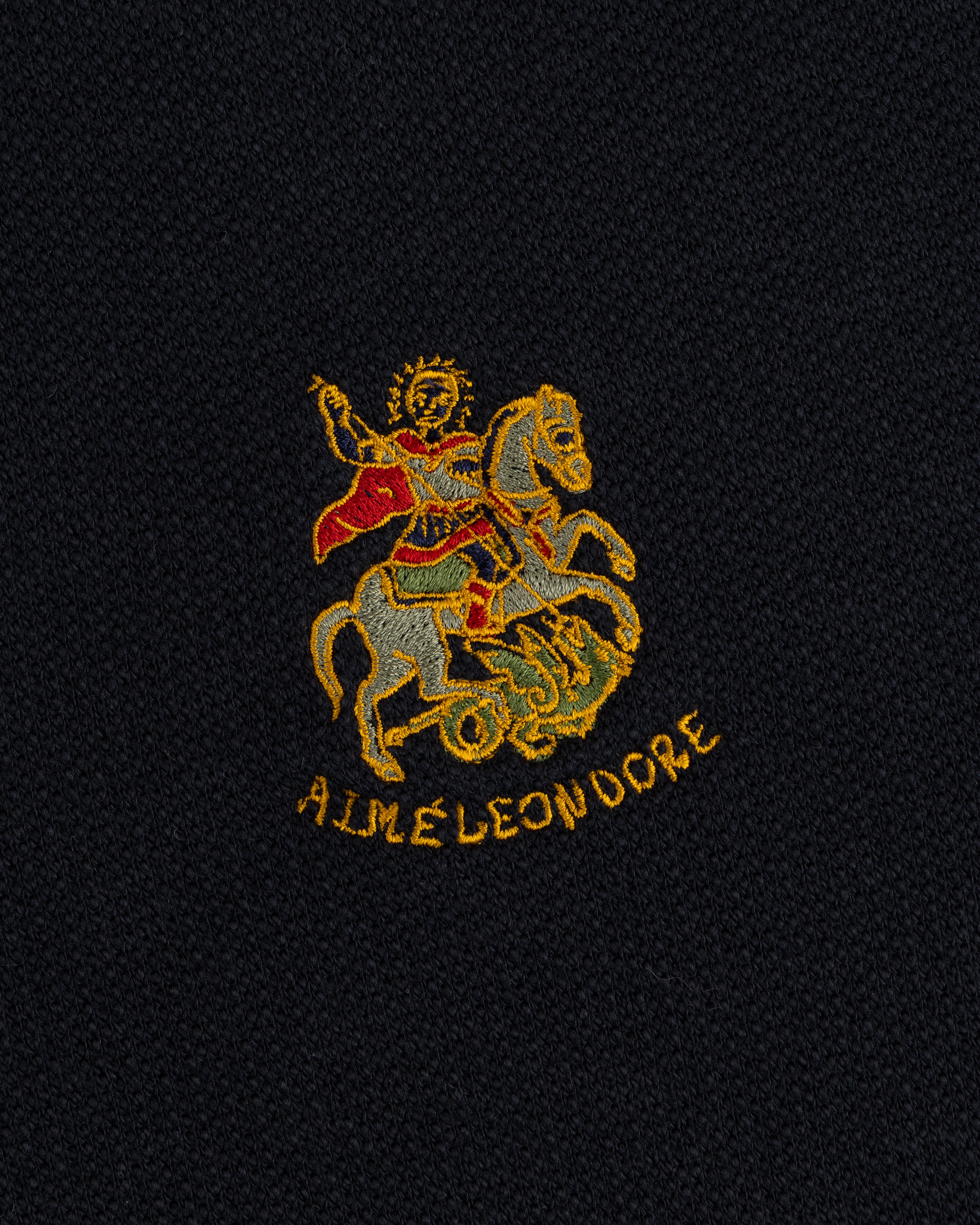Saint George Track Jacket features knight slaying dragon embroidery and AIME LEON DORE text on black fabric.