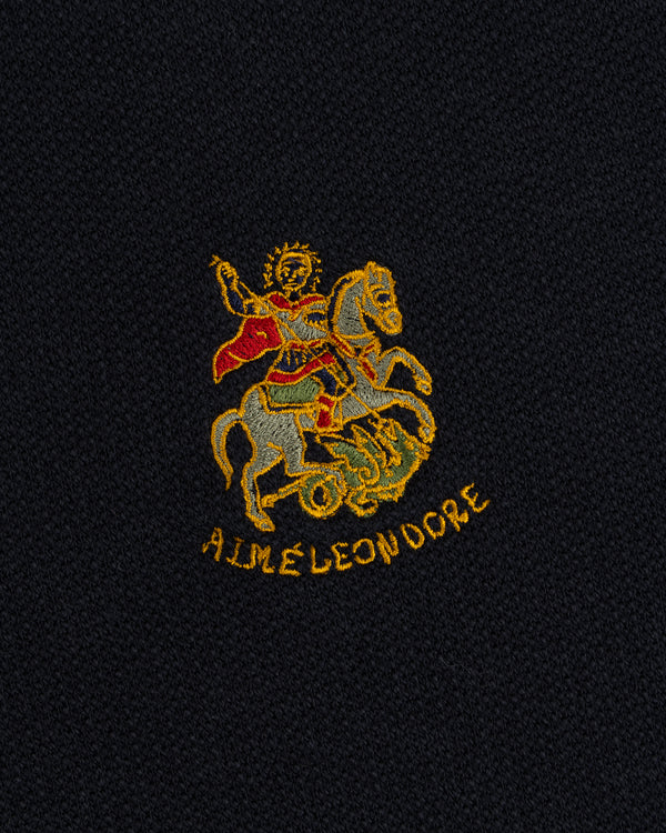 Saint George Track Jacket features knight slaying dragon embroidery and AIME LEON DORE text on black fabric.