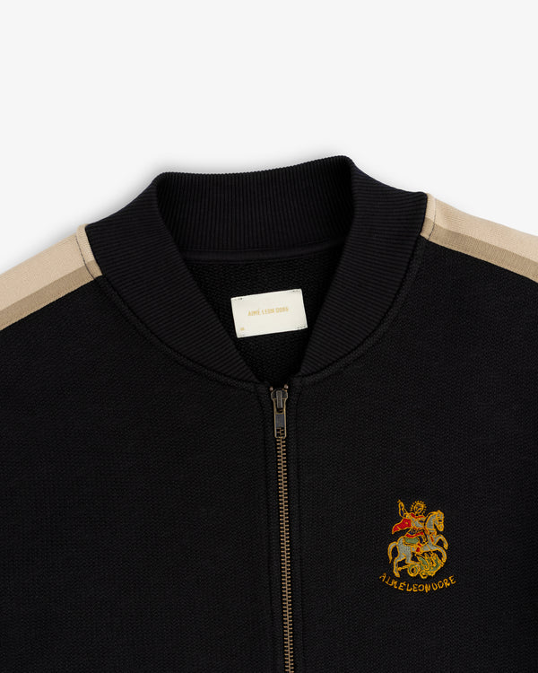 Saint George Track Jacket: Black zip-up, tan shoulder stripes, ribbed collar, knight crest with A.L.I.E.R.O.D.H.O.R.E.